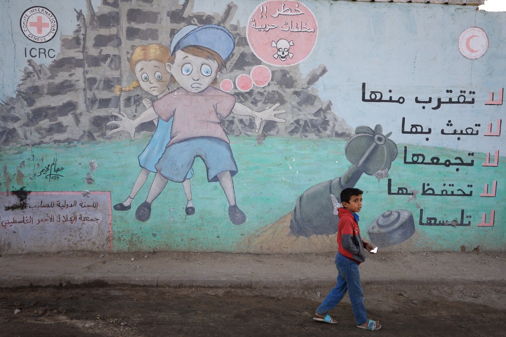 A Palestinian child walks past a mural warning against approaching unexploded ordnance, in Deir Al-Balah in the central Gaza Strip, on October 8. Photo: Reuters