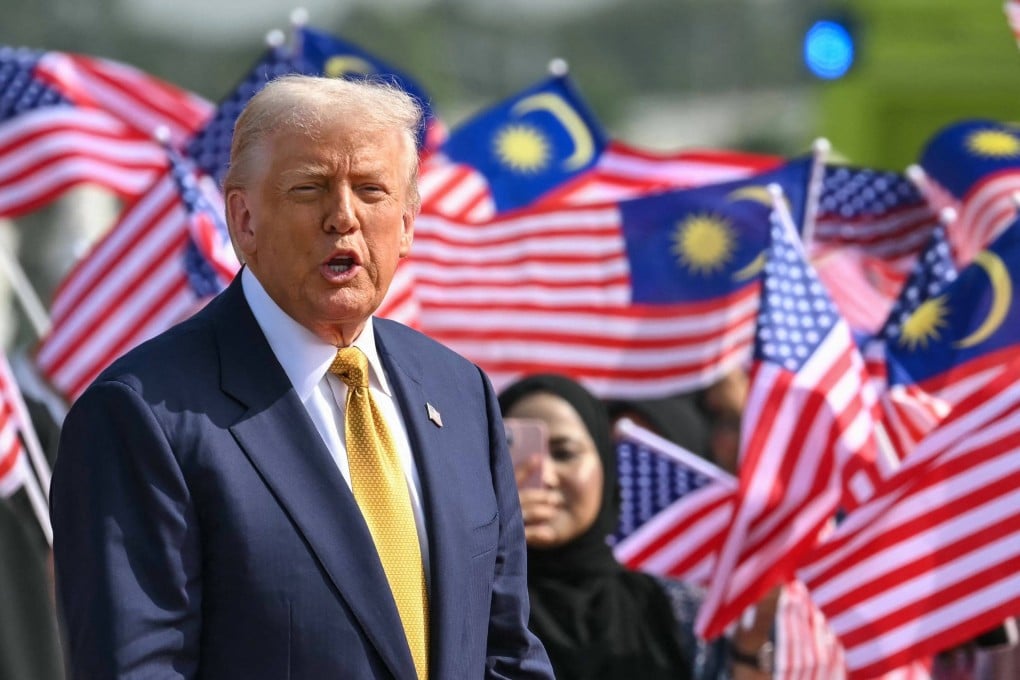 US President Donald Trump looks on next to people waving Malaysian national flags before he departs on Air Force One from Kuala Lumpur International Airport in Sepang on October 27. Photo: AFP