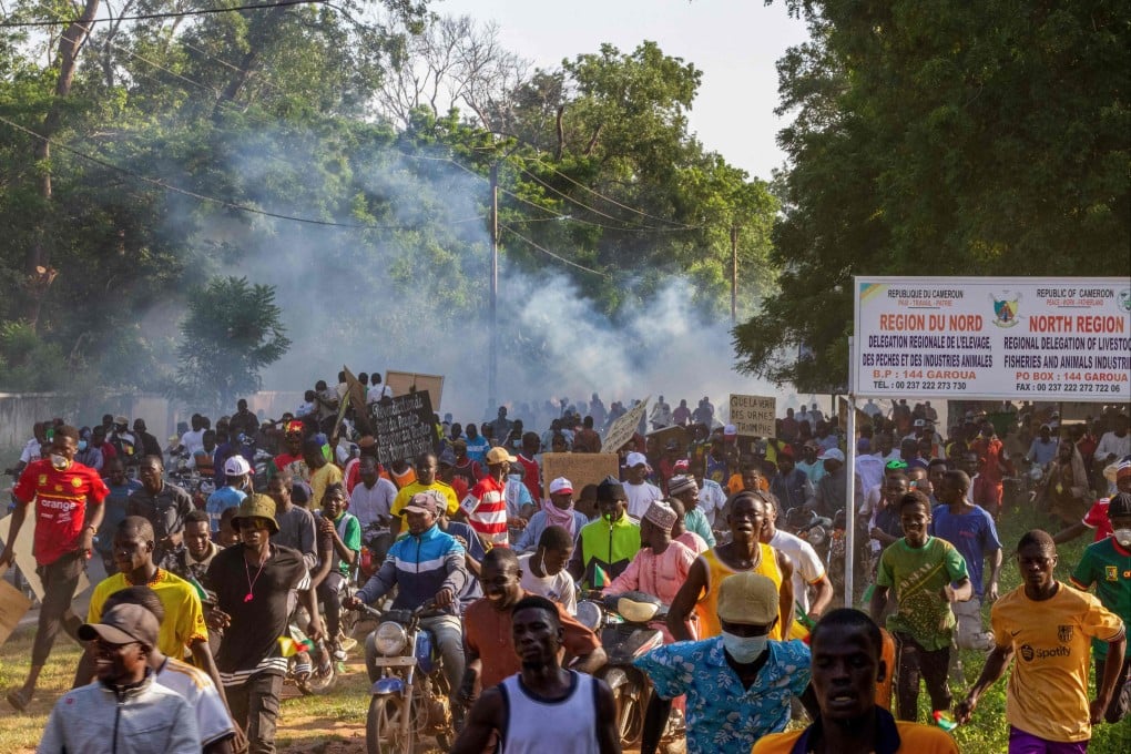 Protesters run after Cameroonian police officers disperse them in Garoua on Sunday. Photo: AFP