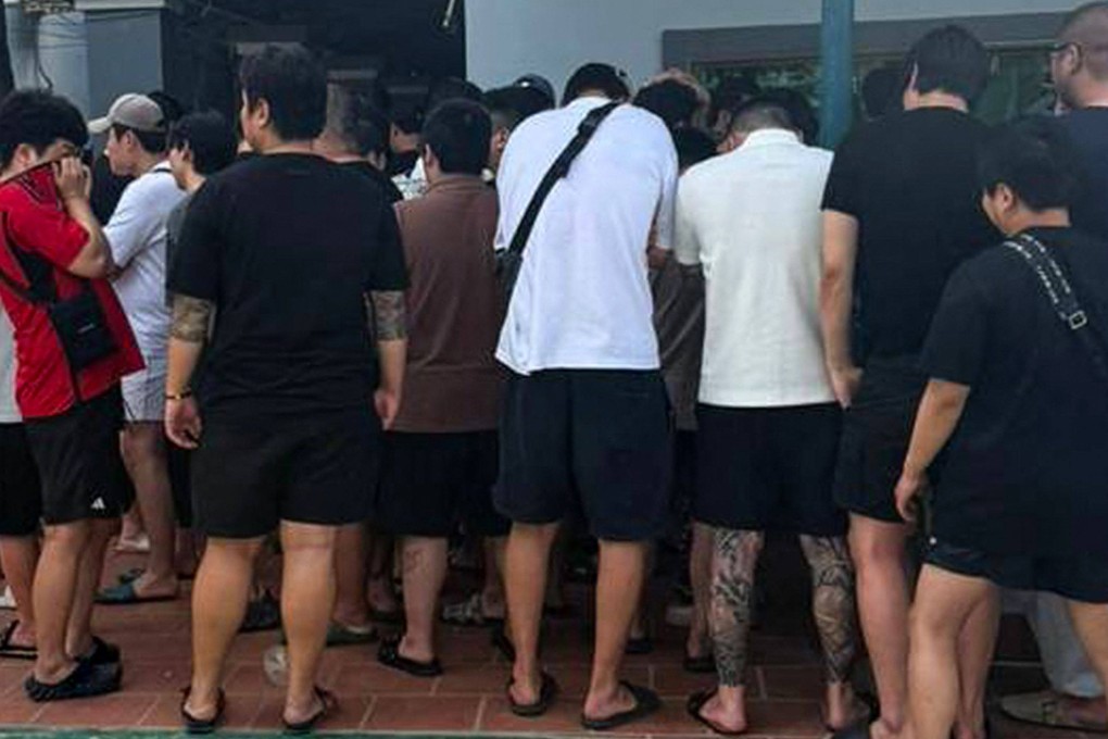 South Koreans suspected of being involved in online scams are herded together during a raid on a scam centre in Phnom Penh on Thursday. Photo: Agence Kampuchea Press/AFP