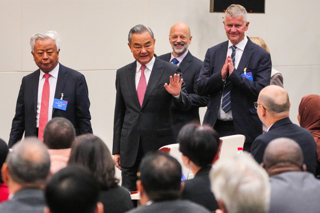 Chinese Foreign Minister Wang Yi waves to foreign diplomats as he arrives to deliver opening remarks at the Lanting Forum on Improving Global Governance to Build a Community with a Shared Future for Humanity in Beijing on Monday. Photo: AP