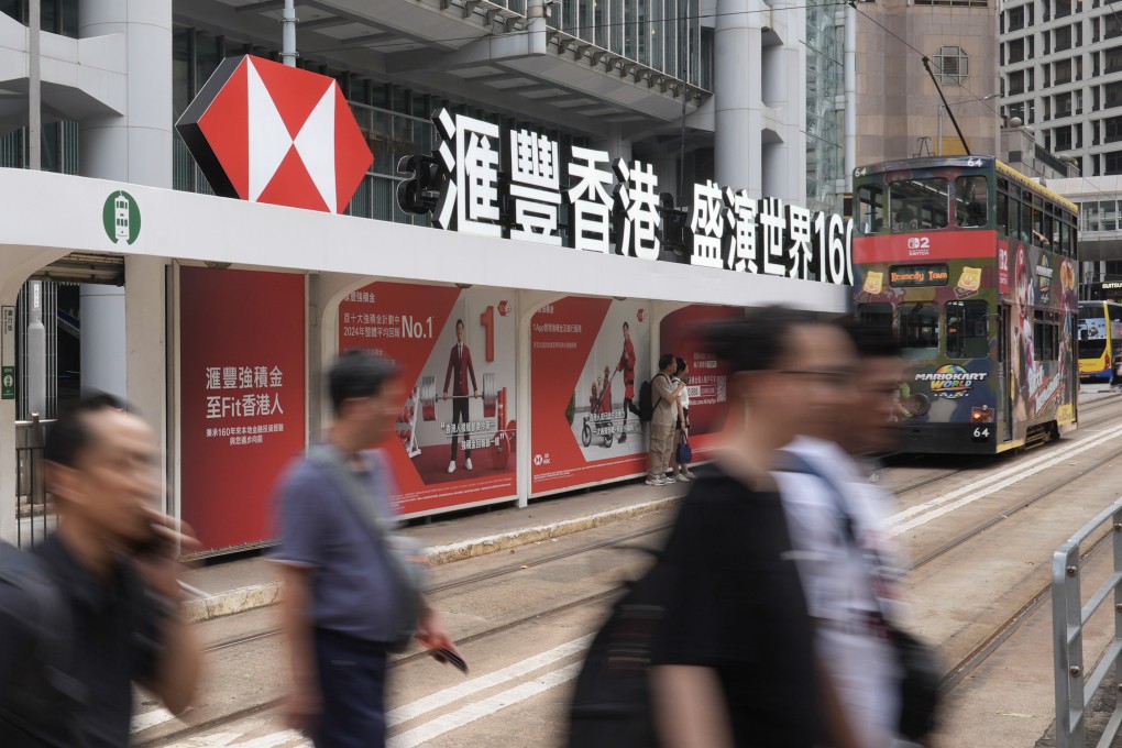 Pedestrians and a tram pass the HSBC building in Central on July 30, 2025. Photo: Eugene Lee