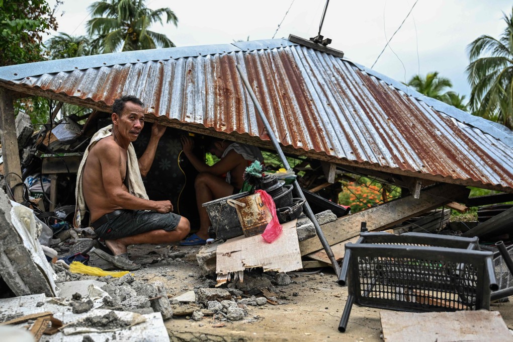 Locals look for items in a collapsed house in Manay, in the province of Davao Oriental on October 11, after two powerful quakes struck off the southern Philippines on October 10. Photo: AFP