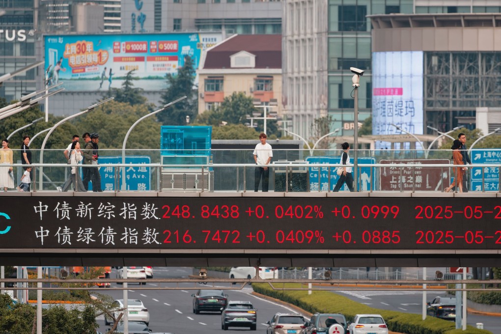 People walk on a pedestrian bridge showing the latest stock exchange and economy data in Shanghai on May 27, 2025. Photo: EPA-EFE