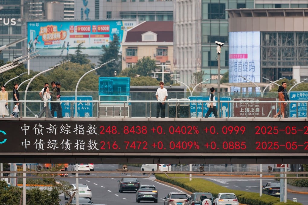 People walk on a pedestrian bridge showing the latest stock exchange and economy data in Shanghai on May 27, 2025. Photo: EPA-EFE