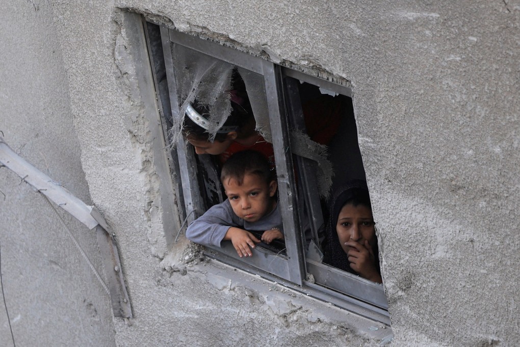 Palestinians look out of a window, near a house hit in an overnight Israeli strike, in Gaza City. Photo: Reuters