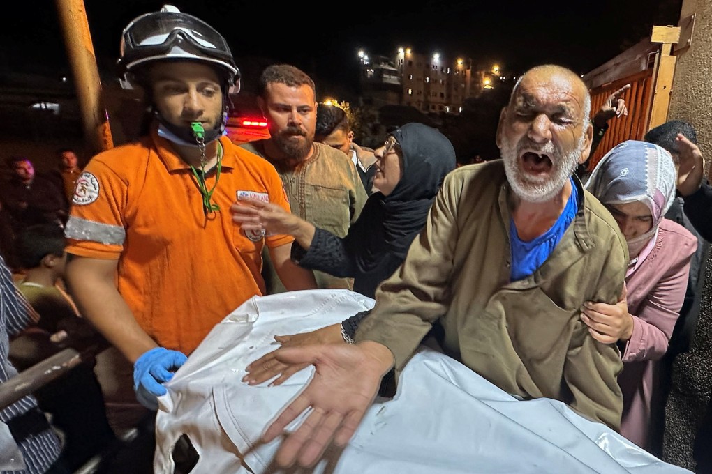 A Palestinian man reacts next to the body of a man, who according to medical workers was killed in an Israeli strike on Tuesday, at Nasser Hospital in Khan Younis. Photo: Reuters