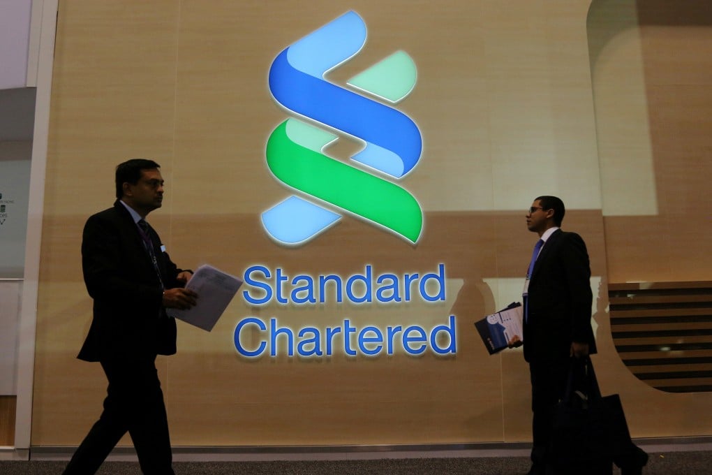 People pass by the logo of Standard Chartered at a banking and financial conference in Toronto, Canada. File photo: Reuters