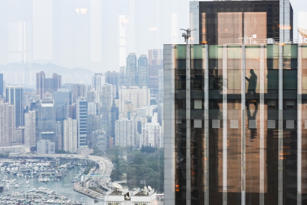 A mirror reflecting a person’s silouette is seen amid commercial and residential buildings on Hong Kong Island, on February 26. Photo: Eugene Lee