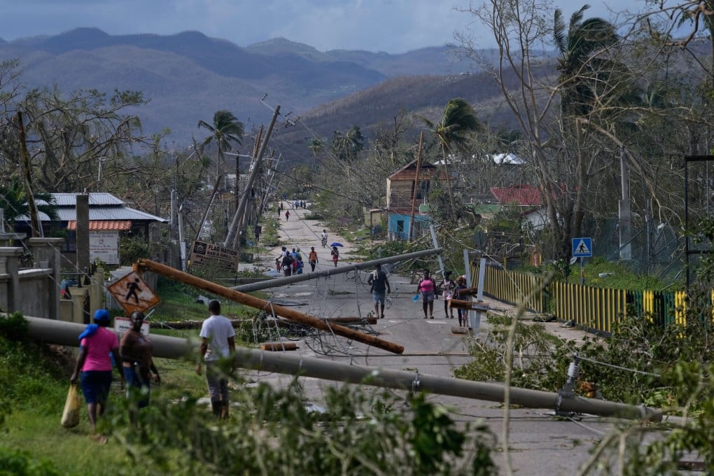 Residents walk through Lacovia Tombstone, Jamaica, in the aftermath of Hurricane Melissa. Photo: AP