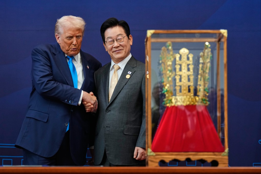 US President Donald Trump shakes hands with South Korean President Lee Jae-myung as he receives a gift of a gold crown during an event in Gyeongju on Wednesday. Photo: AP