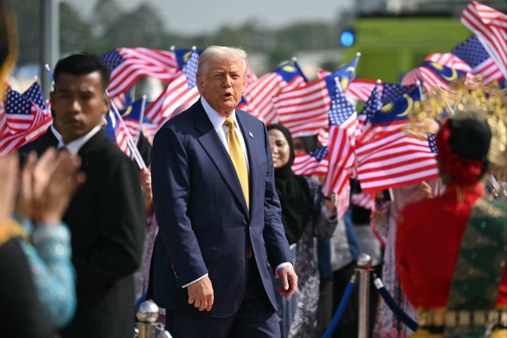 US President Donald Trump looks on as people wave Malaysian national flags before he departs on Air Force One from Kuala Lumpur International Airport on October 27. Photo: AFP
