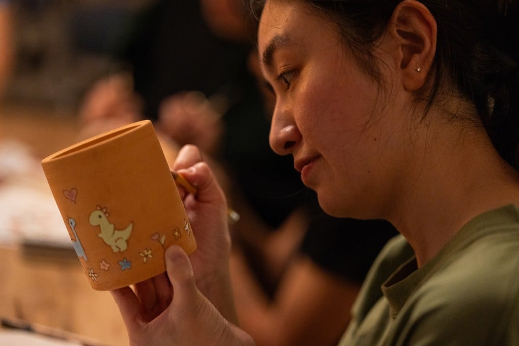 Elaine Chen “tattoos” her mug at Steve Stringer’s “Tattoo a Mug” workshop in Los Angeles, California. Photo: TNS