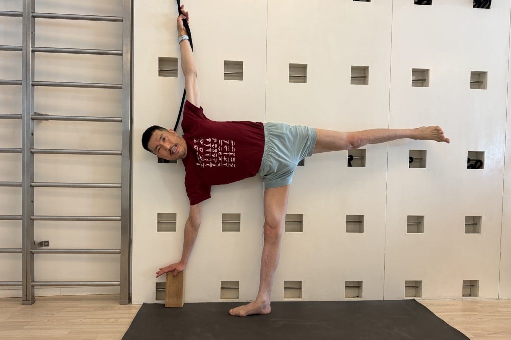 Hong Kong mutual fund executive David Lee uses props to do an Iyengar yoga pose. With regular practice aided by a teacher, yoga is helping slow down the progress of his neurodegenerative disease. Photo: IYCHK