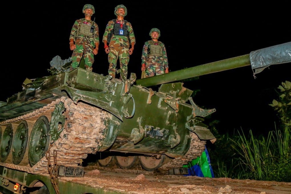 Cambodian soldiers stand atop a tank loaded on a truck along a street in Preah Vihear province on Sunday. Photo: Agence Kampuchea Press/AFP