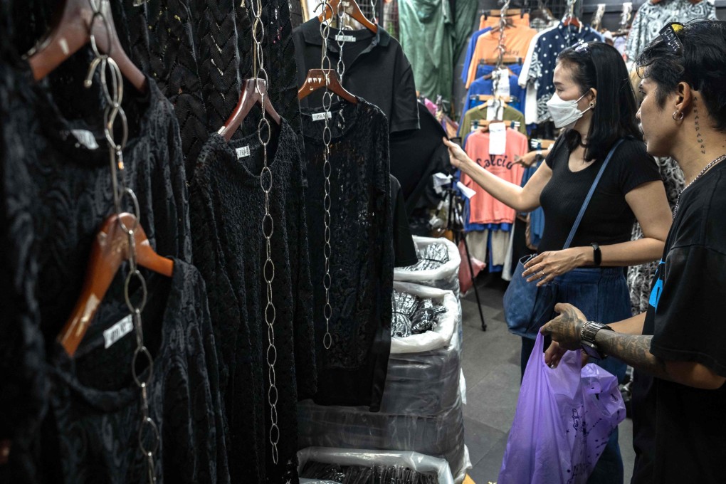 Customers browse for black clothing to mourn the death of Thailand’s former queen Sirikit at a store in Bangkok on Thursday. Photo: AFP