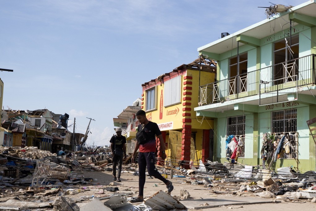 People walk along a street destroyed by Hurricane Melissa in Black River, Jamaica, on Friday. Photo: EPA