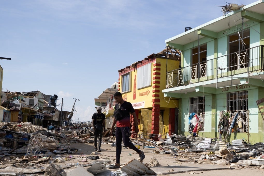 People walk along a street destroyed by Hurricane Melissa in Black River, Jamaica, on Friday. Photo: EPA