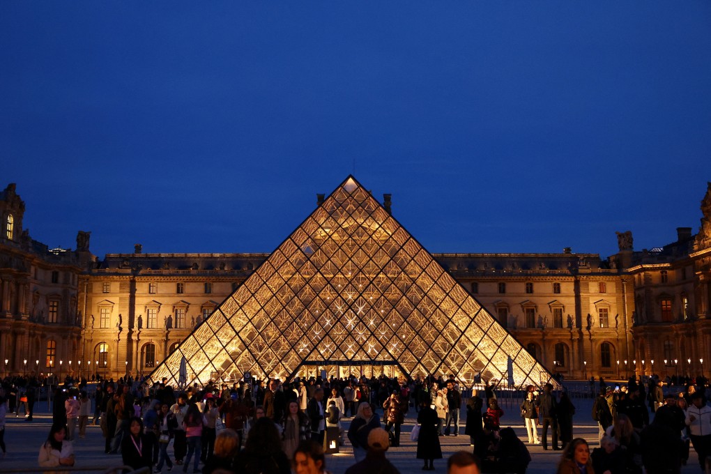 People walk near the glass Pyramid of the Louvre in Paris on Thursday. Photo: Reuters
