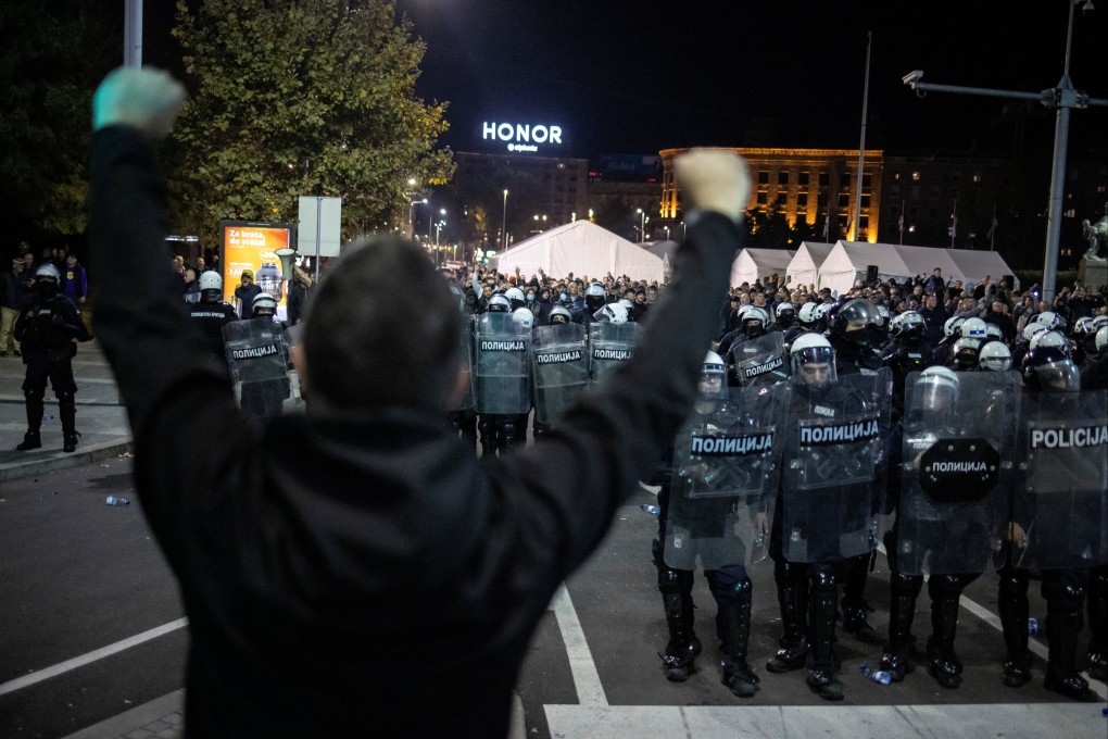 An anti-government demonstrator gestures in front of riot police near the parliament in Belgrade, Serbia, on Sunday. Photo: Reuters