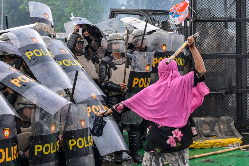 A woman strikes a police officer with a bamboo stick as police push back students during a protest outside the parliament building against lawmakers’ demands for higher allowances, in Jakarta on August 28. Stark inequality fuels mass protests, erodes trust in institutions and tears at the social fabric that holds communities together. Photo: AFP