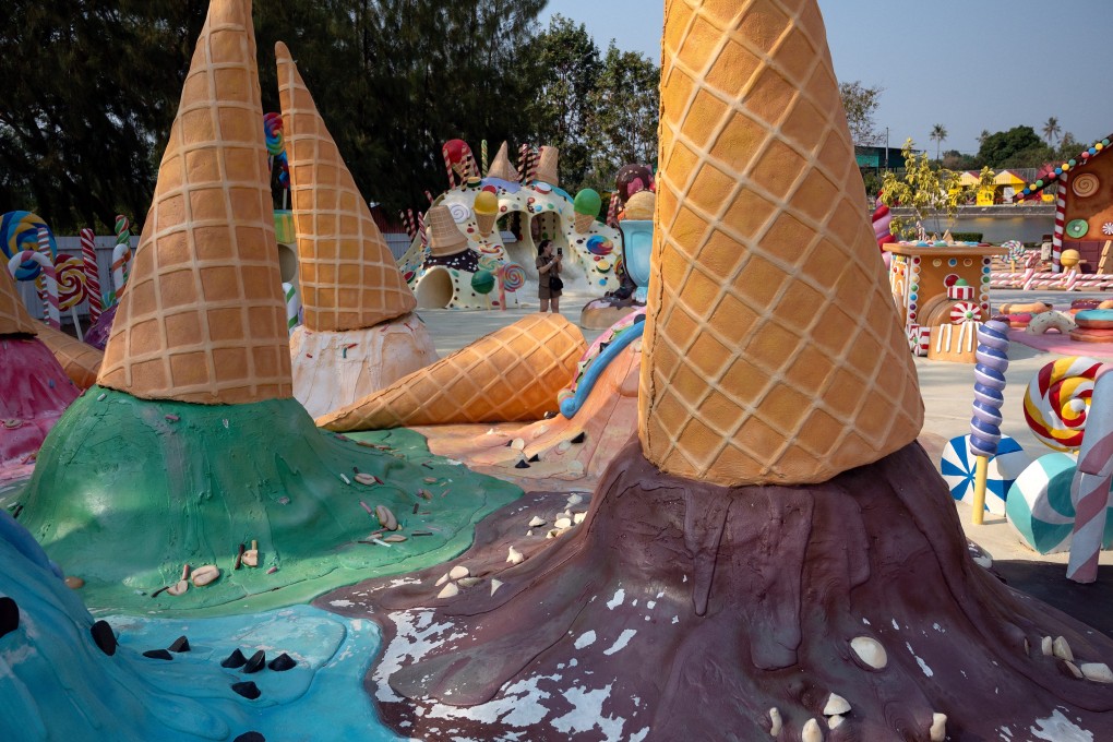 A visitor takes photographs amid colorful ice cream-themed sculptures at cafe and theme park in Pattaya, Thailand. Photo: AFP