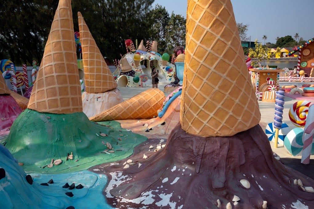 A visitor takes photographs amid colorful ice cream-themed sculptures at cafe and theme park in Pattaya, Thailand. Photo: AFP