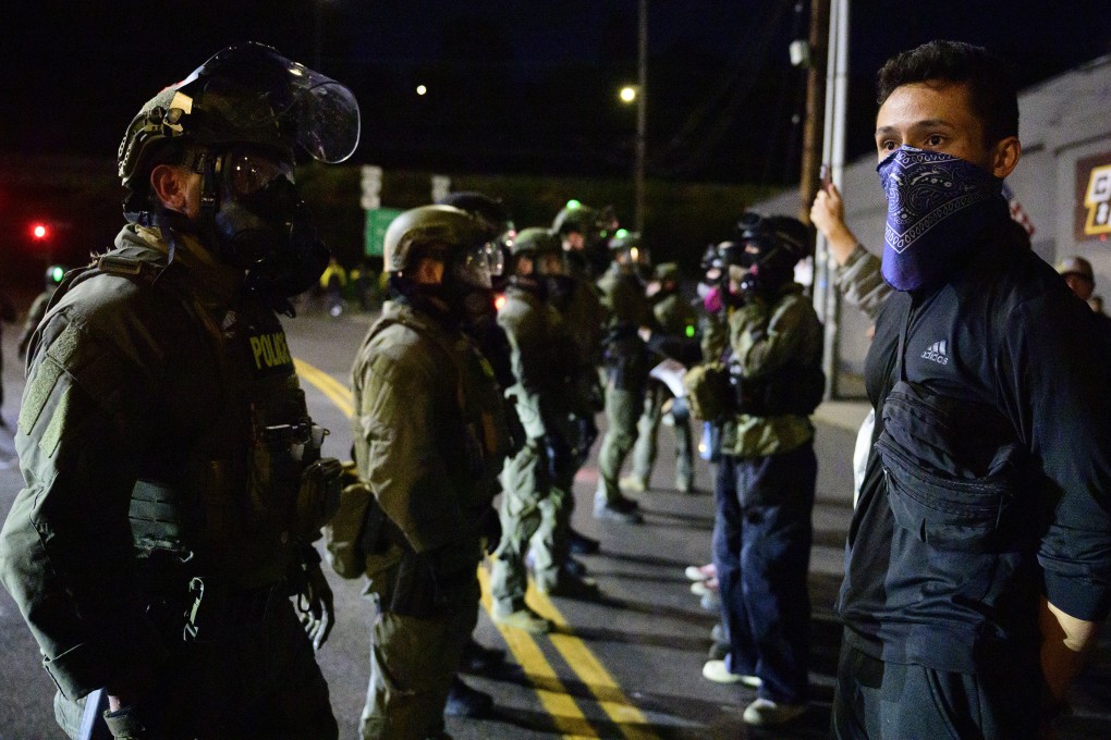 Federal agents stand guard to keep demonstrators away from an Immigration and Customs Enforcement facility in downtown Portland last month. Photo: TNS