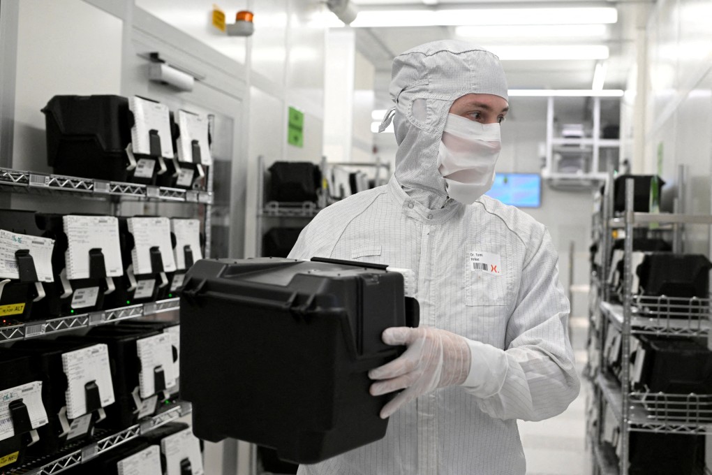 An employee holds a box of wafers on a production line of Dutch semiconductor firm Nexperia. Photo: Reuters