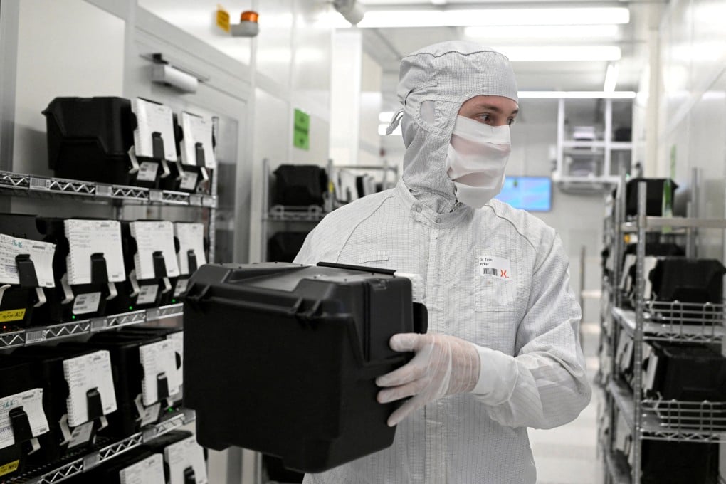 An employee holds a box of wafers on a production line of Dutch semiconductor firm Nexperia. Photo: Reuters