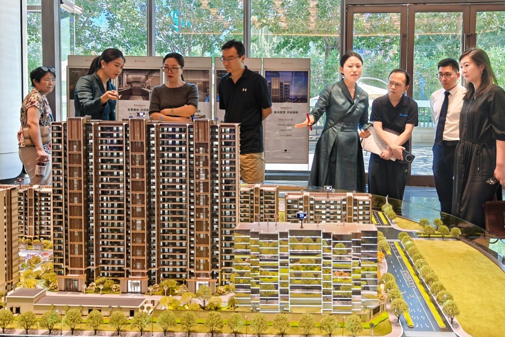 People look at property models at a real estate sales office outside Beijing’s fifth ring road on August 9, after the authorities announced that some purchase restrictions were being removed. Photo: China News Service via Getty Images