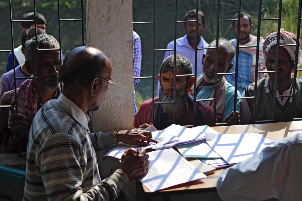 People check their names on the first draft of India’s National Register of Citizens in Assam in 2018. On Thursday, India began revising its voter rolls, raising concerns about potential disenfranchisement in the world’s largest democracy. Photo: AFP