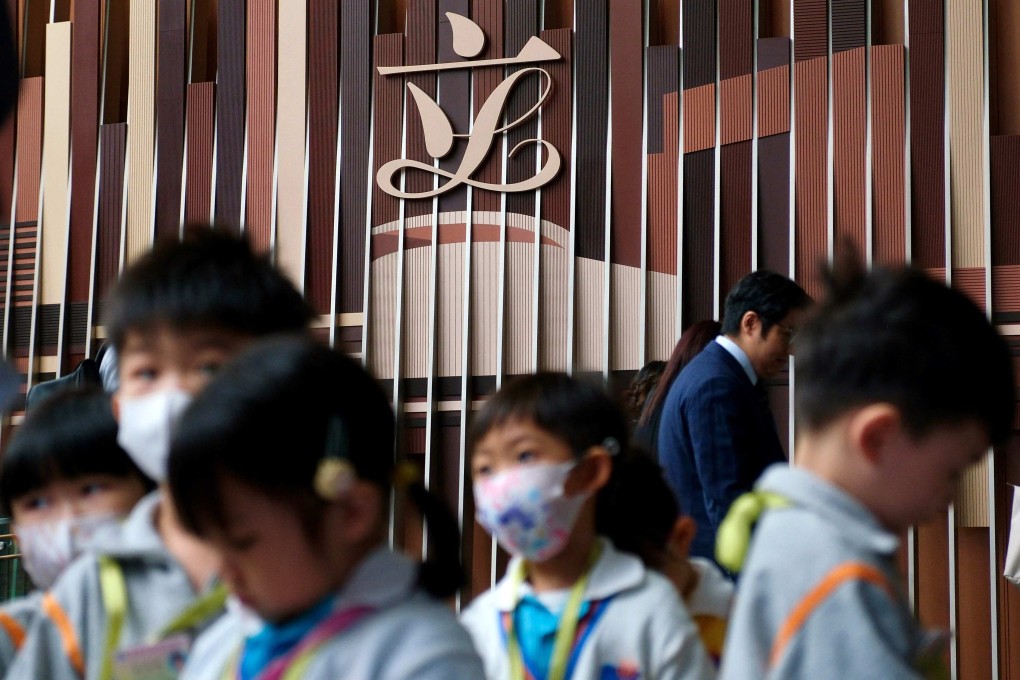 A group of children walk past the Hong Kong Legislative Council signage at the Legco building on October 23. Photo: AFP