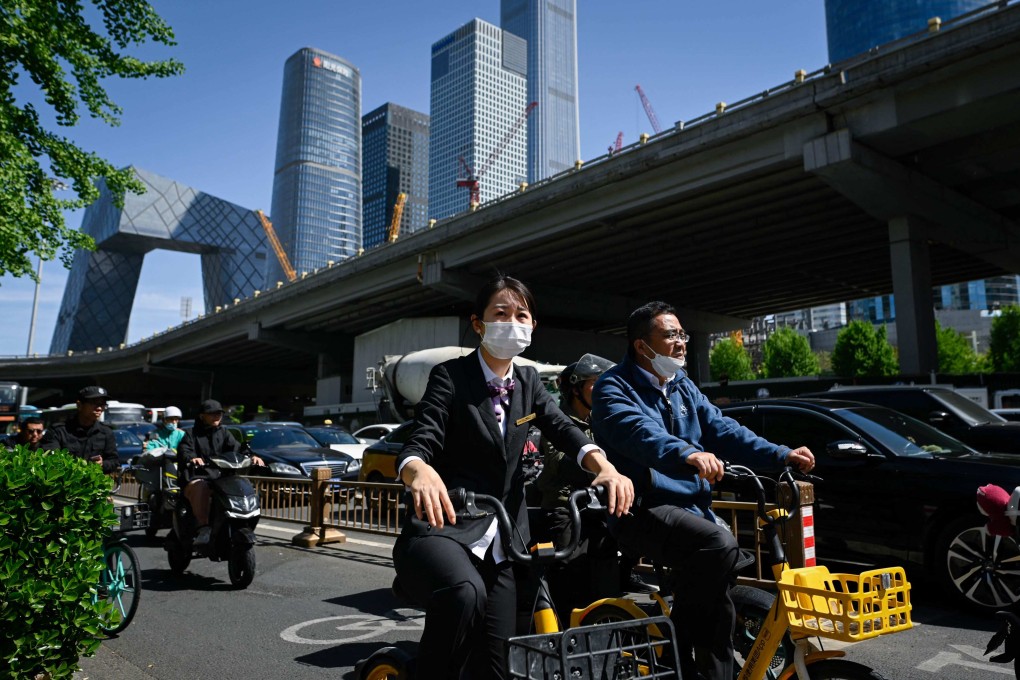 People ride bicycles along a street in Beijing’s business district on April 16, 2024. Photo: AFP