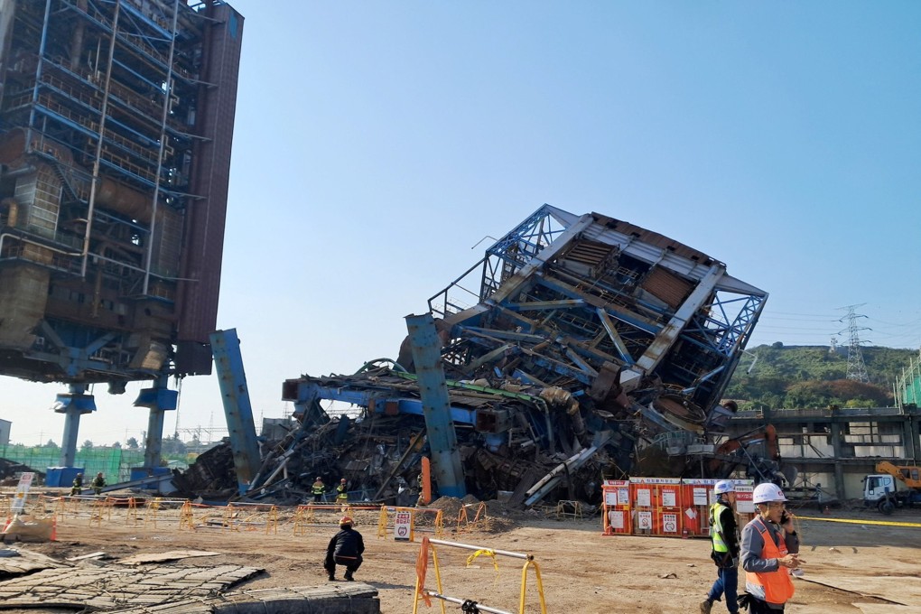 People walk near a large structure which collapse at the Korea East-West Power’s Ulsan Power Plant headquarters, in South Korea, on Friday. Photo: Yonhap/Reuters