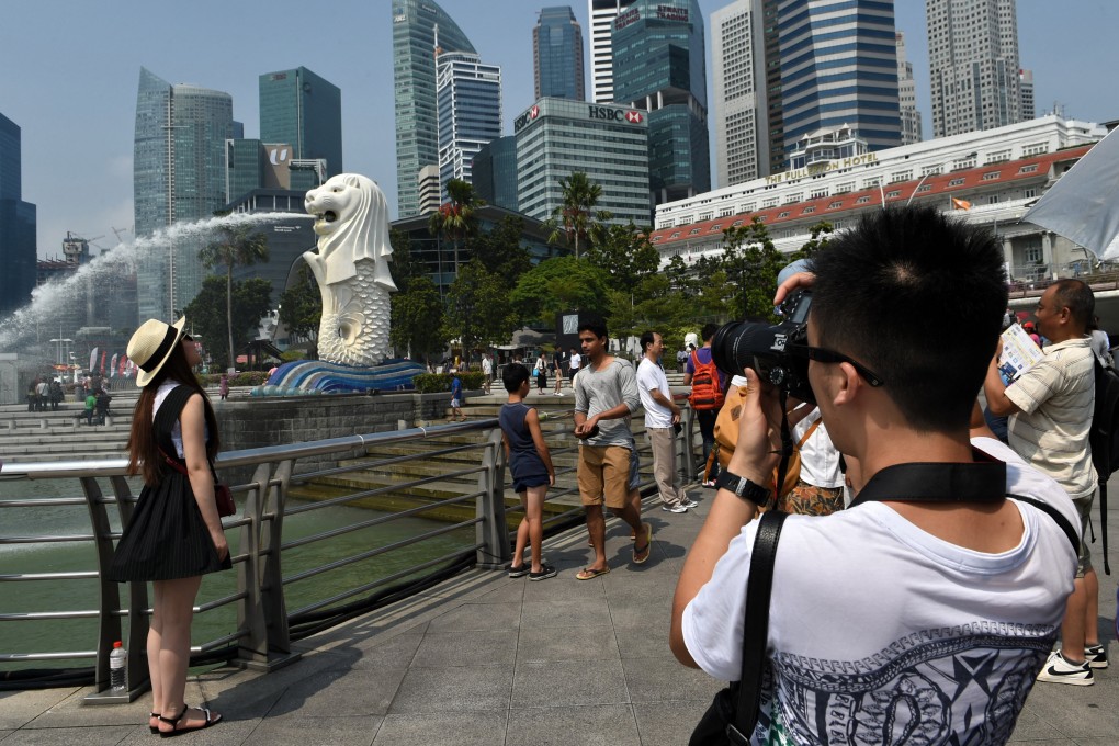 Chinese tourists take pictures near the Merlion statue in Singapore. Photo: AFP