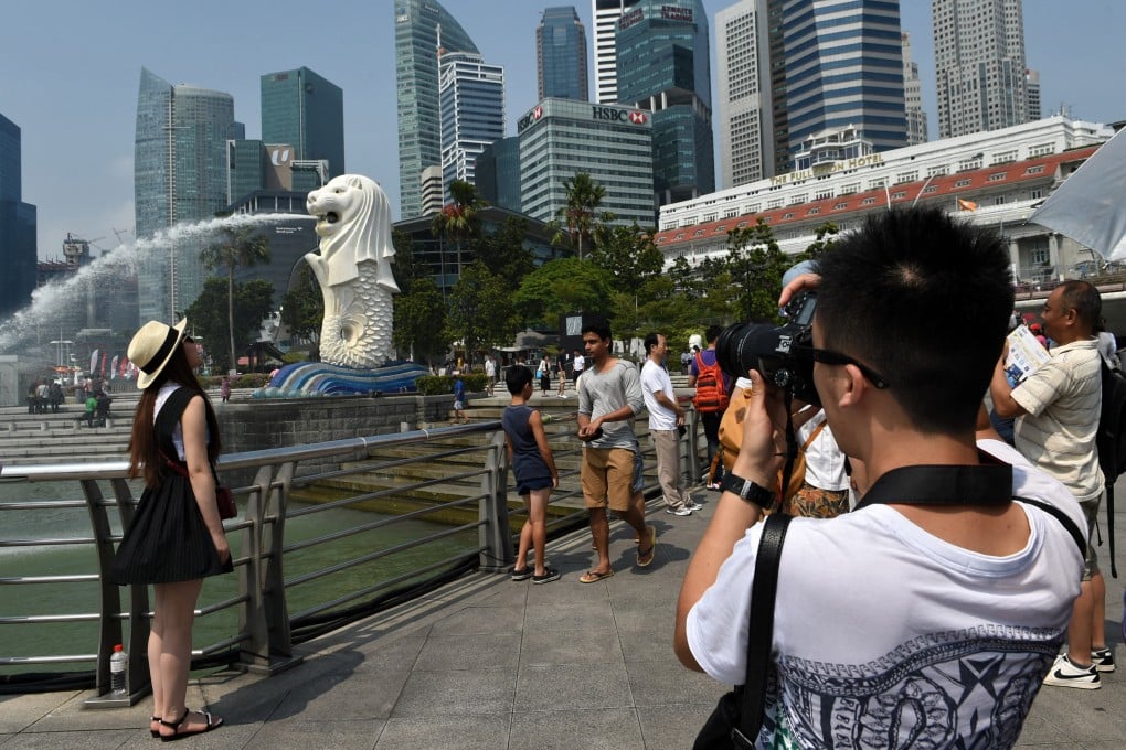 Chinese tourists take pictures near the Merlion statue in Singapore. Photo: AFP