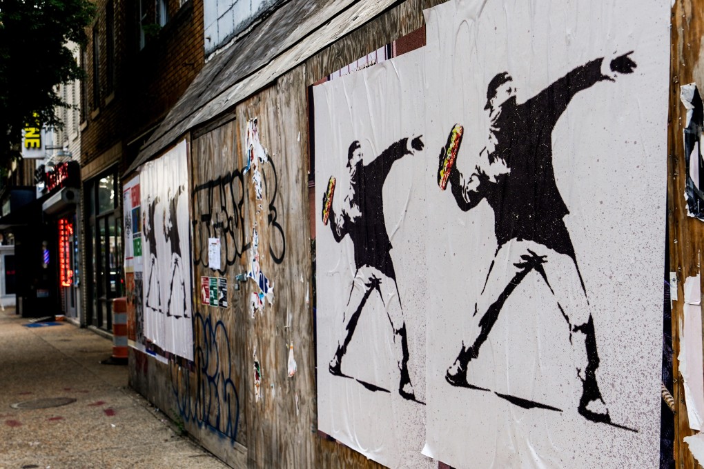Posters of a man throwing a sandwich are pictured in Washington in August. Photo: AP