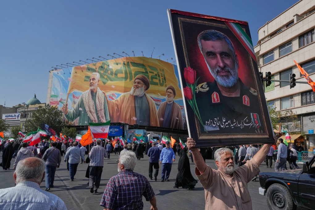 A man in Tehran  in October holds a portrait of Iran’s Revolutionary Guard General Amir Ali Hajizadeh, who was killed in an Israeli strike in June, while a banner shows Quds Force General Qassem Soleimani (left), who was killed in a US drone attack in 2020, and two late Hezbollah leaders. Photo: AP