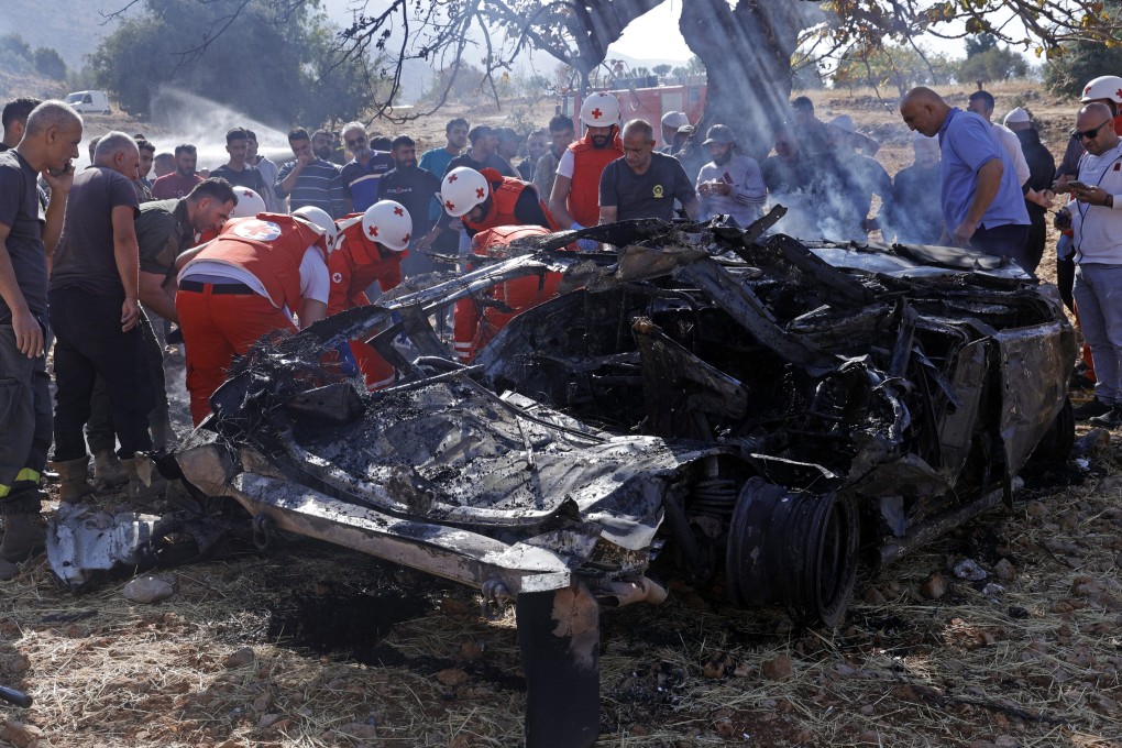 Members of the Lebanese Red Cross inspect the wreckage of a vehicle struck by an Israeli drone in the town of Shebaa on Saturday. Photo: EPA