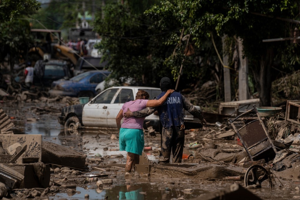 A Marine helps a woman in a flooded street in Poza Rica in Mexico’s Veracruz state in October. Photo: AP