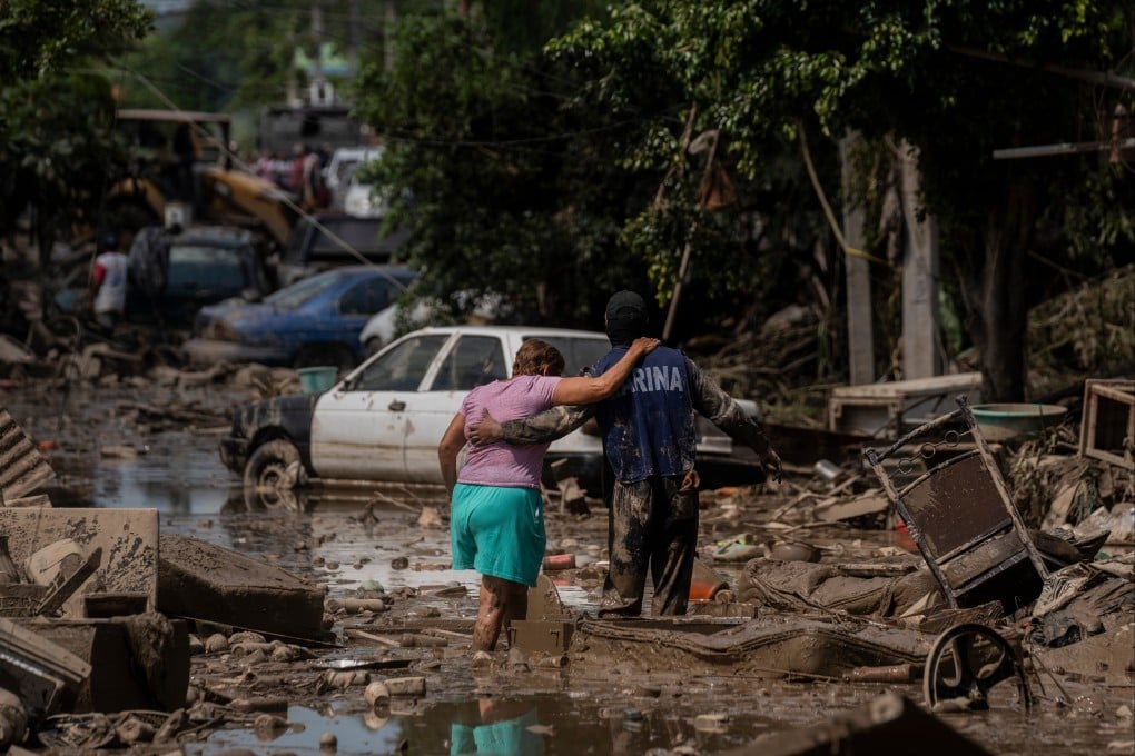 A Marine helps a woman in a flooded street in Poza Rica in Mexico’s Veracruz state in October. Photo: AP