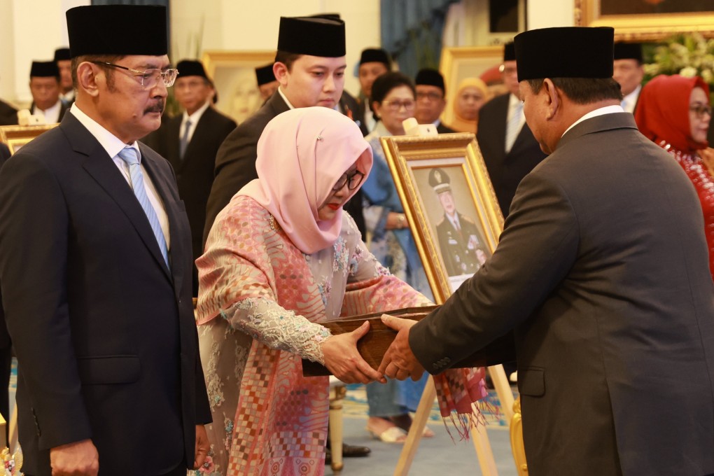 Indonesian President Prabowo Subianto (right) gives a placard to Suharto’s daughter Siti Hardiyanti Rukmana and son Bambang Trihatmodjo. Photo: EPA