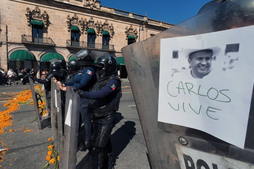 Police officers stand guard as protesters demonstrate against the assassination of Uruapan’s mayor Carlos Manzo, at the Government Palace in Morelia, Michoacan state. Photo: AFP