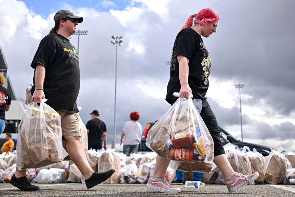 People carry bags of groceries during a free food distribution in Daytona Beach, Florida, on Sunday. Photo: AFP