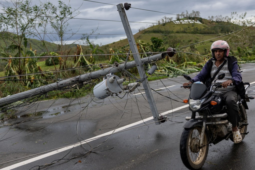 A motorist rides past a fallen post in the aftermath of Typhoon Fung-wong in Cordon, Philippines, on Monday. Photo: Reuters