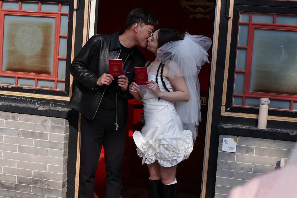 A newlywed couple pose with their marriage certificates after they register at the Huguo Guanyin Temple, in Beijing, China, on October 28, 2025. Photo: Reuters