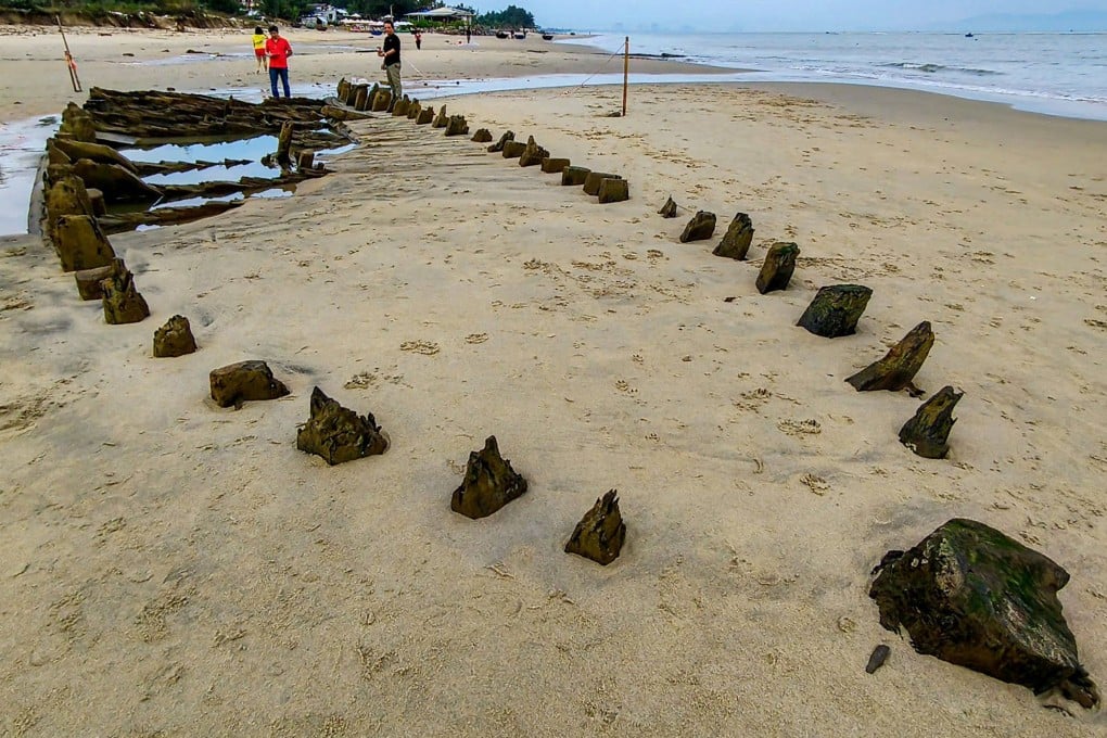People look at a centuries-old shipwreck uncovered in the aftermath of Typhoon Kalmaegi on a beach off Hoi An, Vietnam, on Monday. Photo: AFP