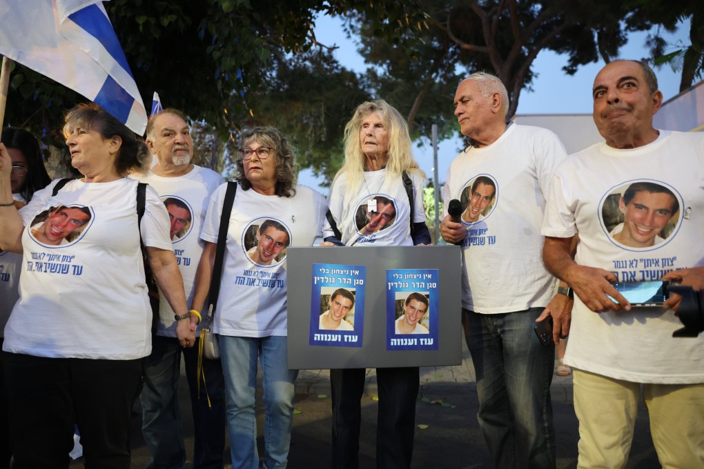 Supporters wearing T-shirts and holding banners with the image of Israeli soldier Hadar Goldin outside the National Centre of Forensic Medicine in Tel Aviv. Photo: EPA