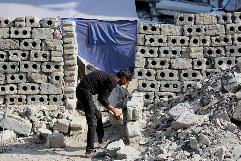 A Palestinian man uses blocks from destroyed buildings to rebuild a shelter in the Al-Shatee refugee camp on November 8. Photo: AFP